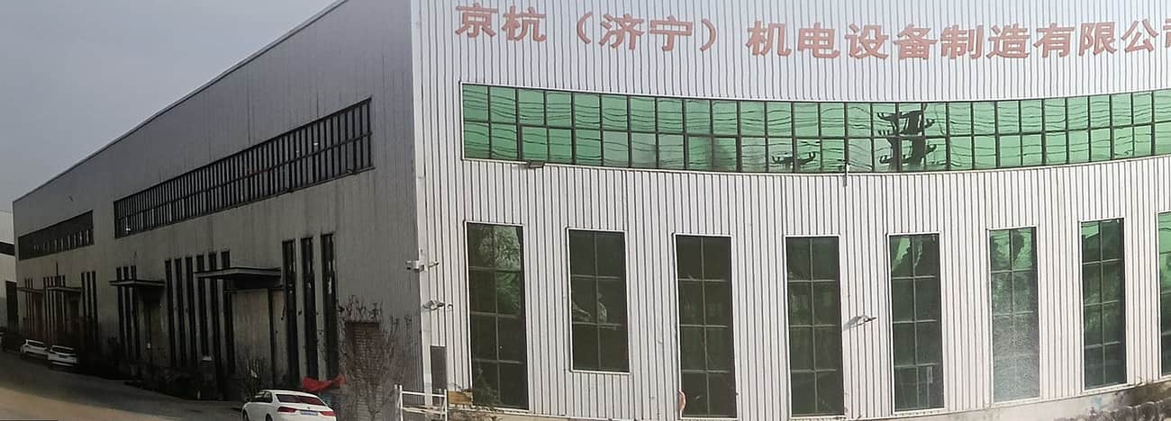 Factory exterior showing the workshop building and the company sign on the roof